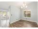 Dining room with wood floors, a modern chandelier, and bright light streaming through the shuttered window at 2842 Mahogany Grove Ave, Henderson, NV 89074