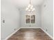 Empty dining room featuring wood flooring, a modern chandelier, and natural light from the window at 2842 Mahogany Grove Ave, Henderson, NV 89074
