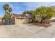 Charming single-story home with a red tile roof, solar panels, desert landscaping, and a two-car garage at 2842 Mahogany Grove Ave, Henderson, NV 89074