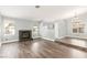 Spacious living room featuring wood flooring, a fireplace, and plenty of natural light from the windows at 2842 Mahogany Grove Ave, Henderson, NV 89074