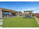 Expansive backyard features an outdoor kitchen, dining area, covered seating, and manicured synthetic lawn at 2913 Grande Arch St, Henderson, NV 89044