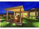 Inviting backyard with covered patio, fire pit, and lush artificial turf, perfect for outdoor entertaining at 2913 Grande Arch St, Henderson, NV 89044