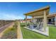 Lush backyard featuring multiple seating areas, a pergola, and a built in firepit with mature landscaping at 2913 Grande Arch St, Henderson, NV 89044