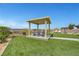 Beautiful backyard with lush synthetic lawn, a modern pergola, and serene views of the surrounding landscape at 2913 Grande Arch St, Henderson, NV 89044