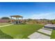 Landscaped backyard featuring a modern pergola with lounge seating and manicured lawn with views at 2913 Grande Arch St, Henderson, NV 89044