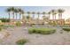 Well-maintained community entrance with lush landscaping, palm trees, and decorative wall at 2913 Grande Arch St, Henderson, NV 89044
