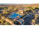 Aerial view of a community pool and clubhouse surrounded by palm trees, lush landscaping, and parking at 2913 Grande Arch St, Henderson, NV 89044