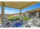 Relaxing covered patio with modern furniture, a fire pit, and great views of the landscaped backyard at 2913 Grande Arch St, Henderson, NV 89044