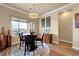 Cozy dining area with a round table, modern chandelier, and large windows offering scenic views at 2913 Grande Arch St, Henderson, NV 89044