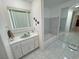 Bathroom with vanity and sink, bathtub with tiled surround, and large mirror creating an open feel at 3110 National Ave, Pahrump, NV 89048