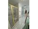 Bright bathroom featuring tiled floors, walk-in shower with gold accents, and accessibility features at 3110 National Ave, Pahrump, NV 89048