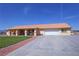 Charming single-story home featuring a vibrant lawn, long driveway, and a terracotta-colored tiled roof at 3110 National Ave, Pahrump, NV 89048