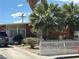 Cozy single-story home featuring a white picket fence, mature trees, and a concrete driveway at 3115 Emmons Ave, North Las Vegas, NV 89030