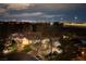 Nighttime aerial view of the home, showcasing its lush landscaping, pool, and proximity to city lights at 3240 W Richmar Ave, Las Vegas, NV 89139