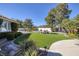 Beautiful backyard with green lawn, mature trees, landscaping, and an umbrella covered outdoor dining set at 3240 W Richmar Ave, Las Vegas, NV 89139