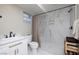 Modern bathroom with a glass block window, marble shower, and white vanity at 3240 W Richmar Ave, Las Vegas, NV 89139