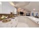 Kitchen with stainless steel sink and backsplash, marble countertops, white cabinets and a view of the living area at 3240 W Richmar Ave, Las Vegas, NV 89139