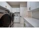 Spacious laundry room with modern washer and dryer, white cabinetry, and sleek countertops at 3240 W Richmar Ave, Las Vegas, NV 89139
