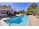 Inviting backyard pool with patio area, lush landscaping, and comfortable seating under the umbrella at 3240 W Richmar Ave, Las Vegas, NV 89139