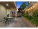 Brick backyard patio featuring outdoor dining table and chairs with lush landscaping at 3268 Grayson Lake Ct, Las Vegas, NV 89129