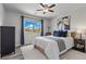 Cozy bedroom features a ceiling fan, comfortable bed, stylish decor and bright natural light from the window at 3268 Grayson Lake Ct, Las Vegas, NV 89129