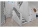Bright foyer with staircase featuring decorative iron railings, a tile floor, and a modern light fixture at 3268 Grayson Lake Ct, Las Vegas, NV 89129