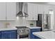 Close-up of modern kitchen with stainless steel appliances, stylish backsplash, and sleek white cabinetry at 3268 Grayson Lake Ct, Las Vegas, NV 89129