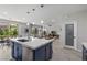 Open kitchen showcasing island with seating, stainless steel appliances, and sliding glass doors to the backyard at 3268 Grayson Lake Ct, Las Vegas, NV 89129