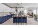Modern kitchen boasts white and navy cabinets, an island with seating, and stainless steel appliances at 3268 Grayson Lake Ct, Las Vegas, NV 89129