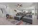 An open-concept living room with a gray sofa, modern decor, flowing into the kitchen and staircase at 3268 Grayson Lake Ct, Las Vegas, NV 89129