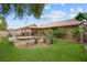 Backyard featuring a covered patio, well-maintained lawn, and lush plants at 36 Trailside Ct, Henderson, NV 89012