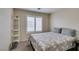 Neutral bedroom featuring window with shutters, carpet flooring, and a decorative shelf at 4417 Gracemont Ave, Las Vegas, NV 89139