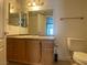 Bathroom featuring granite counters, wood cabinets, large mirror and toilet at 5055 W Hacienda Ave # 2055, Las Vegas, NV 89118