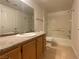 Bathroom featuring granite counters, wood cabinets, large mirror and tub/shower combo at 5055 W Hacienda Ave # 2055, Las Vegas, NV 89118
