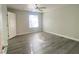 This bedroom features ceiling fan, new gray floors, window with blinds, and white trim at 5055 W Hacienda Ave # 2055, Las Vegas, NV 89118