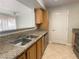 Galley-style kitchen with granite counters and views to living area at 5055 W Hacienda Ave # 2055, Las Vegas, NV 89118