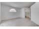 Bright, airy bedroom with wood-look floors, enhanced by an arched window and white walls at 5328 Walton Heath Ave, Las Vegas, NV 89142