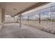 Spacious covered patio with concrete floor, white brick perimeter and metal fencing at 5328 Walton Heath Ave, Las Vegas, NV 89142