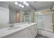 Bathroom featuring a dual sink vanity with white quartz countertops and a glass-enclosed shower at 5641 Morning Snow Ct, Las Vegas, NV 89141
