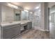 Modern bathroom featuring double sinks, a large mirror with modern lighting, and a luxurious walk-in shower at 5641 Morning Snow Ct, Las Vegas, NV 89141