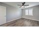 Bedroom with wood-look floors, ceiling fan, and a window with plantation shutters at 5641 Morning Snow Ct, Las Vegas, NV 89141