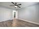 Spacious bedroom featuring wood-look floors, ceiling fan, and closet with large doors at 5641 Morning Snow Ct, Las Vegas, NV 89141