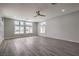 Bright living room with hardwood floors, large windows, and modern ceiling fan at 5641 Morning Snow Ct, Las Vegas, NV 89141