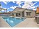 Gorgeous pool featuring a backyard with an outdoor kitchen and covered patio at 5641 Morning Snow Ct, Las Vegas, NV 89141