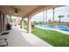 A covered patio overlooking a meticulously maintained lawn, swimming pool with rock features, and backyard at 5815 Pristine Falls Ave, Las Vegas, NV 89131