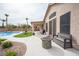 Covered back patio with a ceiling fan, fire pit, and view of the pool and well-manicured backyard at 5815 Pristine Falls Ave, Las Vegas, NV 89131