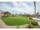 Lush backyard with pristine landscaping, adorned with accent lighting, and a swimming pool area at 5815 Pristine Falls Ave, Las Vegas, NV 89131