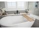 Stylish freestanding tub with a wood tray, white shutters, stone-look backsplash, and black faucet at 5815 Pristine Falls Ave, Las Vegas, NV 89131