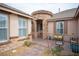 Charming front patio with brick accents and comfortable outdoor seating area with an arched entry at 5815 Pristine Falls Ave, Las Vegas, NV 89131