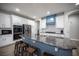 Modern kitchen featuring granite countertops, stainless appliances, a blue accent hood, and seating for three at 5815 Pristine Falls Ave, Las Vegas, NV 89131